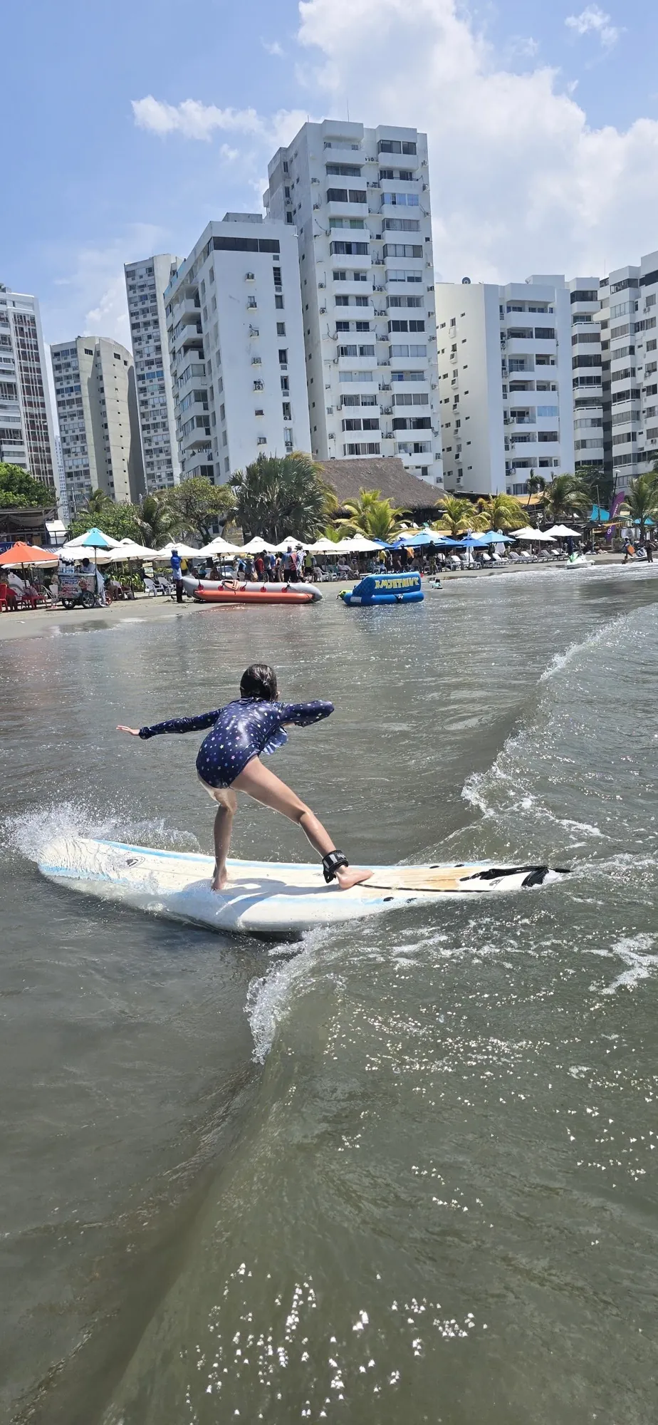 Acción de surf con el skyline de Cartagena de Indias al fondo durante la hora dorada
