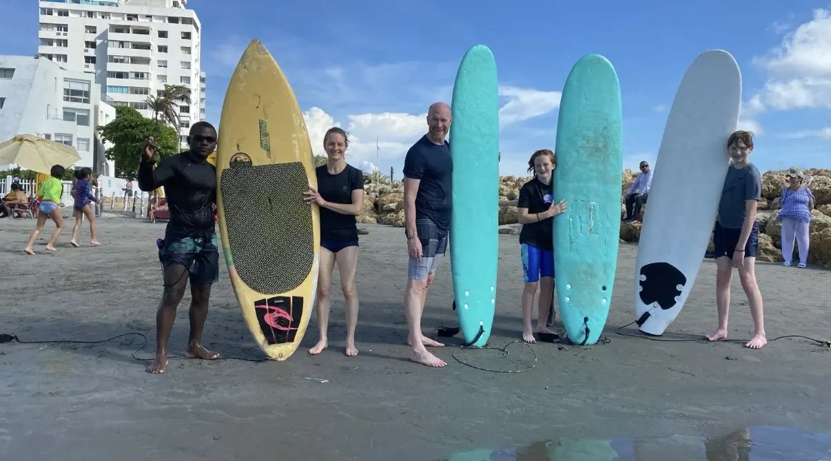 Familia con tablas de surf en la playa de Cartagena lista para una clase de surf