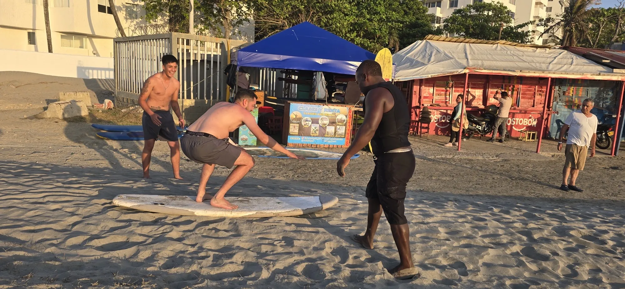Grupo de estudiantes tomando una clase de surf en la playa de Cartagena con instructor