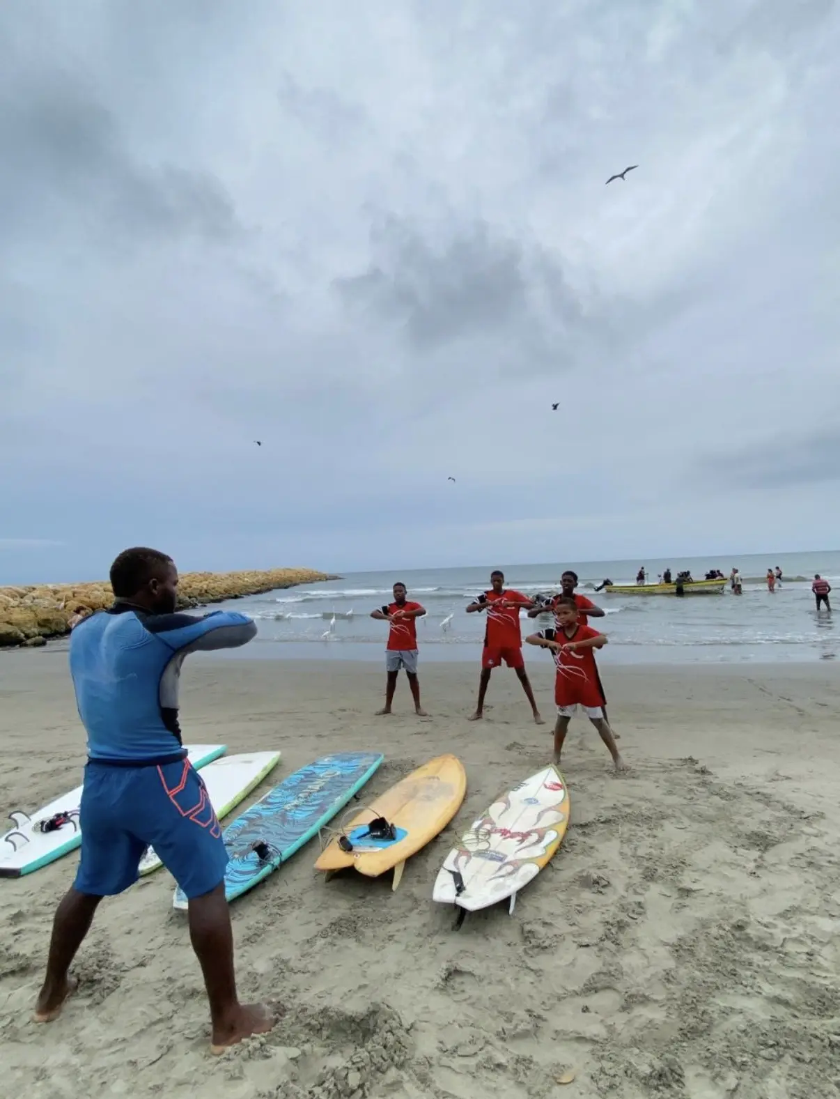 Surf instructor warming up students on the beach