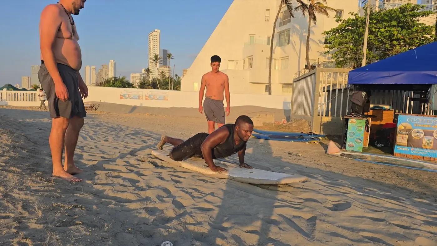 Surfista haciendo un pop-up en hora dorada en la playa de Cartagena