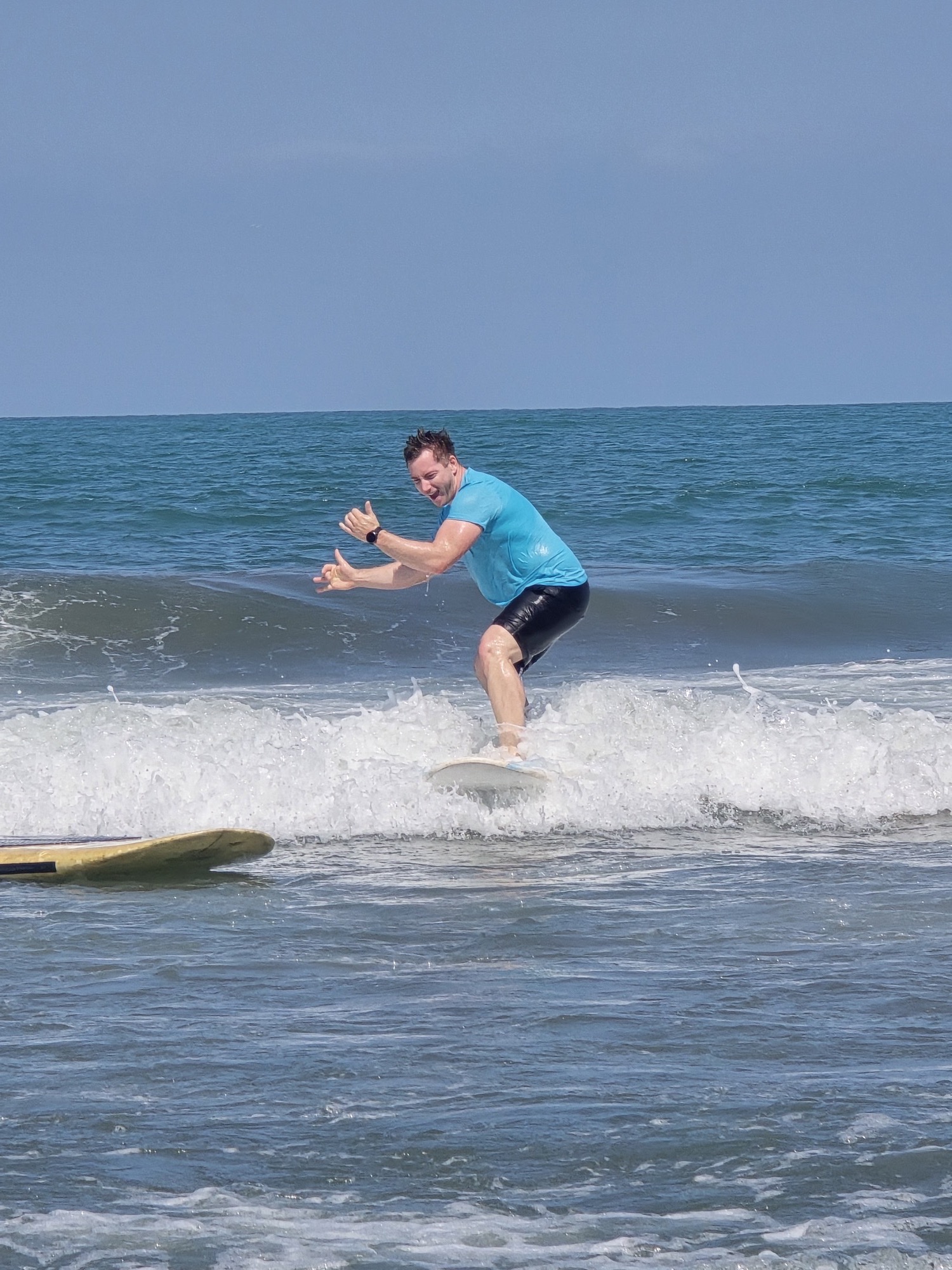 Estudiante de surf de pie sobre una ola de espuma blanca en Cartagena